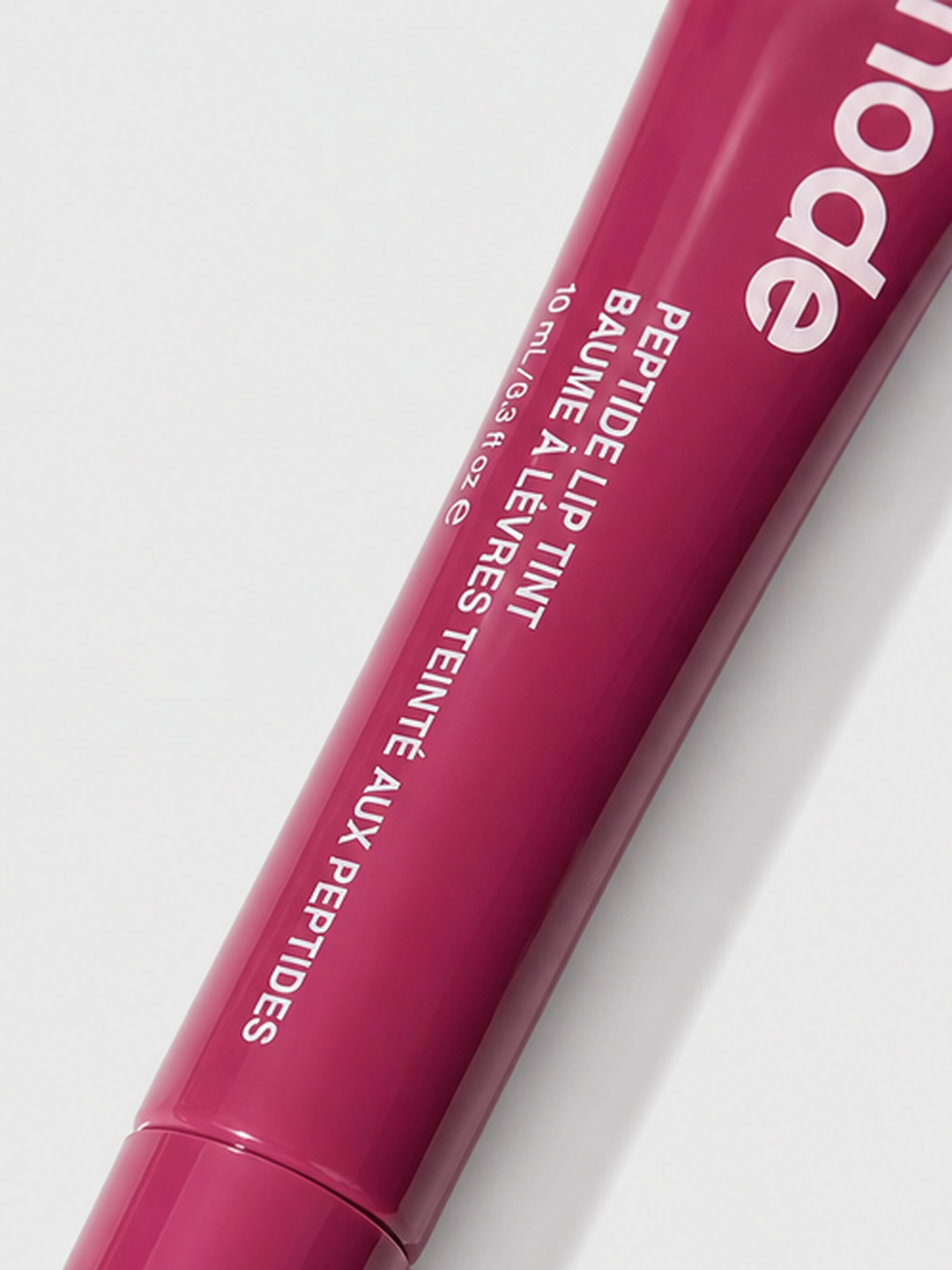 Generated angled close-up of the closed rhode lip tint tube and its printed packaging