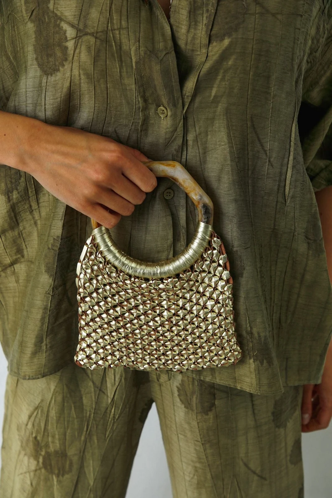 Source image of a small woven metallic bag with a rounded handle